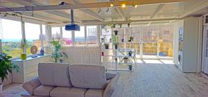 a living room with a couch and some windows at Satori Studio - open plan seaviews private terrace & shared pool in Il-Pergla