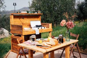 a wooden table with a grill and a table with bread at Stargazer - Glamping Maremma, Toscana in Roccastrada