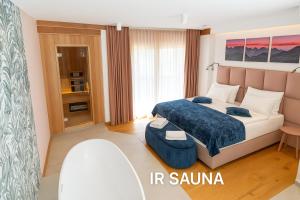 a bedroom with a king sized bed with a blue blanket at Landhouse Bled - Adults Only in Bled