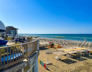 a view of a beach with chairs and the ocean at NINFEA SEAVIEW APARTMENT - Elegant, Bright and Spacious, Steps from the Sea & Station in Nettuno