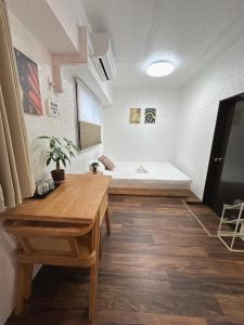 a living room with a bed and a wooden table at Katsu hotel #2 in Osaka