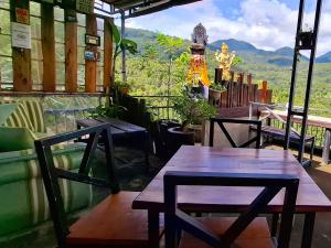 two tables and chairs in a restaurant with a view at Umah de Madya The Room & Panoramic Rooftop Munduk in Munduk