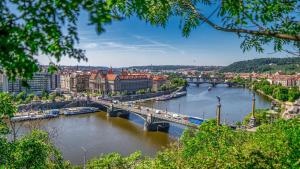 a view of a river with a bridge and buildings at Letenský pokoj Milada E2 in Prague +8 photos