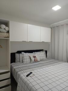 Schlafzimmer mit einem Bett mit Fernbedienung in der Unterkunft Portinari 2 in Rio das Ostras