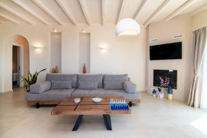 ein Wohnzimmer mit Sofa und Tisch in der Unterkunft Horizon Hill Villa in Tinos
