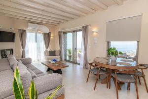 ein Wohnzimmer mit Sofa und Tisch in der Unterkunft Horizon Hill Villa in Tinos