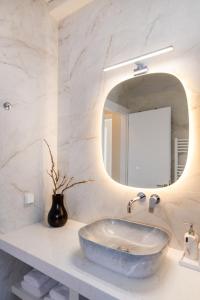 ein Badezimmer mit großem Waschbecken und Spiegel in der Unterkunft Horizon Hill Villa in Tinos