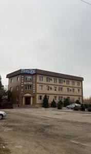 a large building with a parking lot in front of it at Жана Тау in Semey