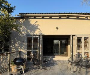 a patio with chairs and a grill in front of a house at Ingonyama Rest in Marloth Park