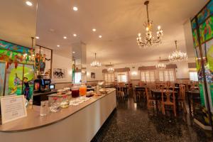 a restaurant with a bar and tables and chandeliers at Hotel Ariston Riccione in Riccione