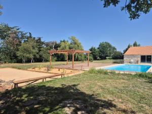 a swimming pool with a pavilion next to a house at Domaine du Chêne Vert in Sallertaine