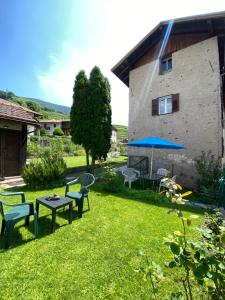 a yard with benches and a table and a building at El Me Popo in Segonzano