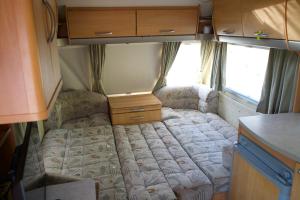 un piccolo letto sul retro di un camper di Peaceful Caravan Escape a Costa da Caparica