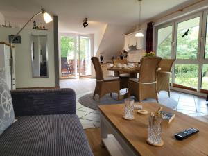 une cuisine et un salon avec une table et des chaises dans l'établissement Ferienwohnung Am Sommerdeich, à Sankt Peter-Ording