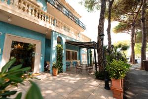 a building with a patio with tables and chairs at Hotel Ariston Riccione in Riccione