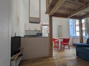 a kitchen with a counter and a table with red chairs at Prealba 2 in Levanto