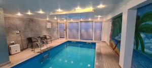 a swimming pool with a table and chairs next to it at Private swimming pool sweet dreams in Sarajevo