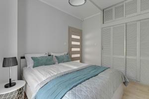 a bedroom with a large bed with blue pillows at Haffnera 19 - Sea & City Moments by Lion Apartments Sopot in Sopot +8 photos