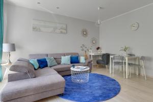 a living room with a couch and a blue rug at Haffnera 19 - Sea & City Moments by Lion Apartments Sopot in Sopot