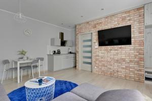 a living room with a tv on a brick wall at Haffnera 19 - Sea & City Moments by Lion Apartments Sopot in Sopot