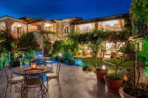 a patio with tables and chairs in a courtyard at Hotel Mariposas in Villasimius