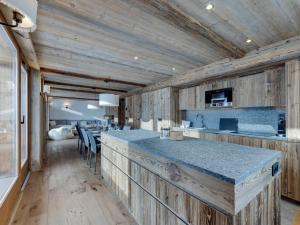 una cucina con pareti in legno e bancone con sedie di Appartement 4 chambres à Tignes le Lac, proche des pistes, cheminée, parking couvert - FR-1-641-20 a Tignes