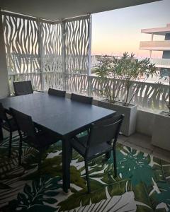 a table and chairs in a room with a large window at Les terrasses du port in Canet-en-Roussillon