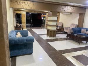 a lobby with blue couches and chairs and a table at Siveen Hotel in Amman