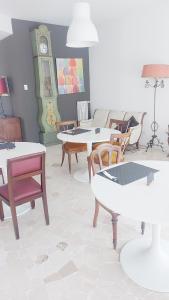 ein Wohnzimmer mit Tischen, Stühlen und einer Uhr in der Unterkunft Torregiardino in Abbiategrasso