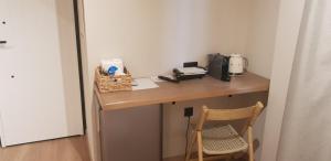 a wooden desk with a microwave and a chair at Sard K Suites in Lefkada