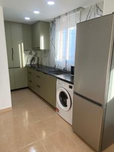 a kitchen with a refrigerator and a washing machine at Duplex Deluxe in Torreblanca +30 photos