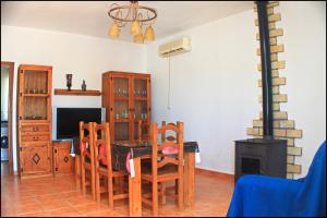 comedor con mesa, sillas y fogones en Chalet Pinar de Roche 118, en Conil de la Frontera