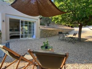 ル・ボーセにあるCabanon Tihou bain nordique privatif petit déjeuner gourmand piscineのパティオ(椅子、テーブル、パラソル付)