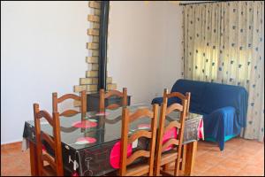 une salle à manger avec une table et des chaises en verre dans l'établissement Chalet Pinar de Roche 118, à Conil de la Frontera