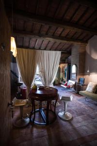 a living room with a wooden table and two stools at Morelliana4Rooms in Scansano +147 photos