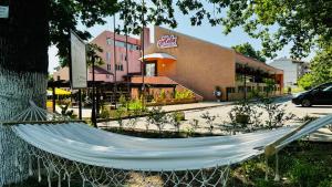 a hammock in front of a store with a building at Hotel Neva in Kiten