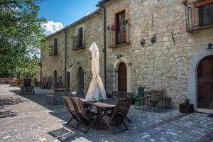 a table with an umbrella in front of a building at Pallano in Bomba
