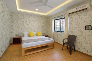 a bedroom with a bed and a chair in it at Budget Friendly Home Stay at CALANGUTE G0A in Candolim