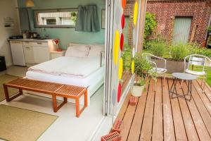 a porch with a bed and a table on a balcony at Kleines Gartenhaus in Havixbeck