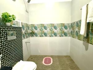 y baño con aseo rosa y ducha. en GAJAPATI by Modern Haven, en Jāmb 6 fotos más