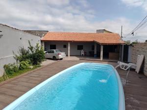 a swimming pool in front of a house at CASA NA PRAIA ITANHAEM para 10 pessoas com total conforto in Itanhaém