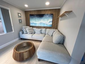 a living room with a couch and a table at Riverside Retreat in Karuah