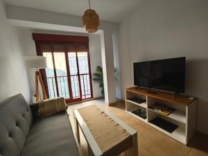 a living room with a couch and a flat screen tv at Apartamento Portonovo-Baltar in Portonovo