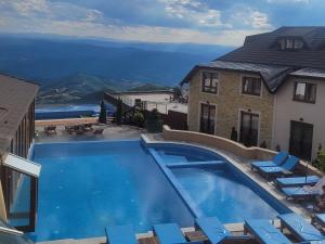 a swimming pool with chairs and a house at Milmari N66 in Kopaonik