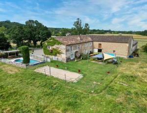une vieille maison en pierre avec une piscine et une cour dans l'établissement Gîte avec piscine, à Graulhet