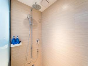 a shower with a shower head on a wooden wall at Hanting Hotel Beijing Qianmen Street in Beijing
