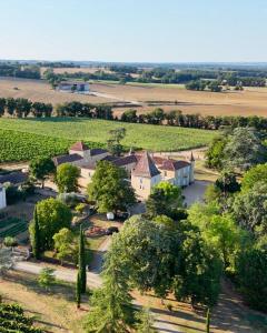 an aerial view of a farm with trees and a building at Domaine du Château Larroque in Sainte-Christie