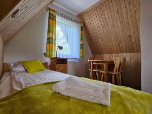 Schlafzimmer mit einem Bett, einem Fenster und einem Tisch in der Unterkunft Pokoje Gościnne Staszelówka in Małe Ciche