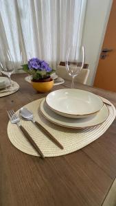 a wooden table with a plate and fork and knife at Loft novíssimo com banheira imersão aquecida a 5min da Vila Germânica in Blumenau