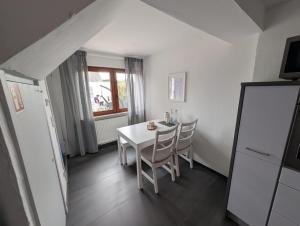 a dining room with a white table and chairs at Ferienhaus Lubentiusblick Limburg in Limburg an der Lahn